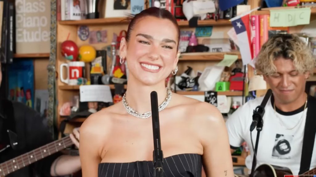 Genera un título atractivo y optimizado para SEO para el artículo "Dua Lipa elimina el 'optimismo radical' para Tiny Desk
". El título debe ser emocionante y contener una palabra clave relevante, no colocar las iniciales de cada palabra con mayúsculas, sino que la mayúscula debe ir únicamente si es necesario según las reglas gramaticales, es decir la primer palabra si debe empezar con mayúscula asi como tambien los siglas, número romanos, nombres propios, como los nombres de personas, animales, lugares, países, ciudades, regiones, continentes, ríos, montañas, etc. Limita el título a 60 caracteres, pero asegúrate de que sea irresistible para los lectores.